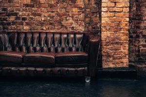 interni classici moderni neri con divano chester in pelle marrone capitone. foto