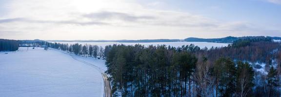 bella veduta aerea dell'enorme lago ghiacciato nel mezzo di una foresta in lettonia. lago ghiacciato ungurs in lettonia. foto