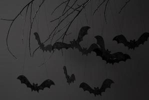 halloween con sagome di pipistrelli neri su un ramo di albero su uno sfondo scuro foto