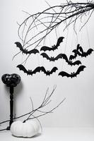 halloween con pipistrelli neri e zucche su un albero su sfondo bianco foto