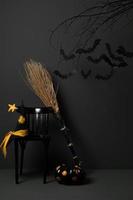 halloween con pipistrelli neri su un albero con una zucca e un cappello su sfondo scuro foto