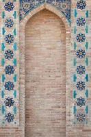 arco e muro di mattoni con mosaico. i dettagli dell'architettura dell'Asia centrale medievale foto
