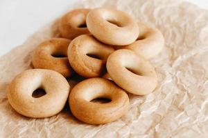 asciugatura o mini bagel rotondi su sfondo di carta kraft. copia, spazio vuoto per il testo foto