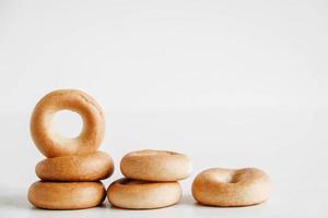 essiccazione o mini bagel rotondi su uno sfondo di legno bianco. copia, spazio vuoto per il testo foto