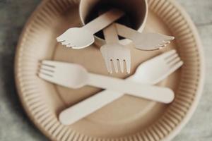 forchette di legno e bicchieri di carta con piatti su fondo di legno