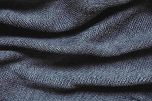 trama di materiale a maglia grigio come immagine di sfondo. lavorare a maglia sui ferri da maglia foto