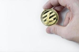 la mano tiene un litecoin su uno sfondo bianco. foto