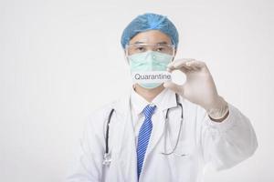 il medico sta tenendo la carta di quanrantina su sfondo bianco foto
