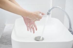 una donna si lava le mani foto