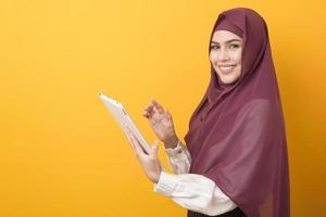 bella studentessa universitaria con ritratto hijab su sfondo giallo foto