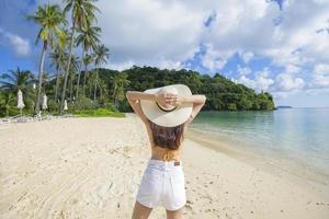 una bella donna felice in bikini giallo che si gode e si rilassa sul concetto di spiaggia, estate e vacanze