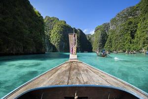 vista della tradizionale barca a coda lunga tailandese sul mare limpido e sul cielo nella giornata di sole, isole phi phi, tailandia foto