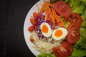 insalata di verdure su fondo di legno nero foto