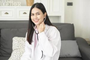 ritratto di dottoressa con stetoscopio in ufficio e sorridente alla telecamera. foto