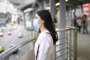 una giovane donna indossa una maschera per il viso nella città di strada.