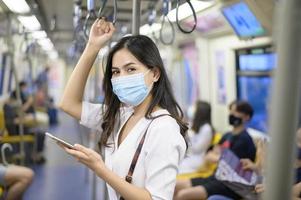 una giovane donna indossa una maschera protettiva in metropolitana, protezione covid-19, viaggi di sicurezza, nuova normalità, distanziamento sociale, trasporti di sicurezza, viaggi in condizioni di pandemia. foto