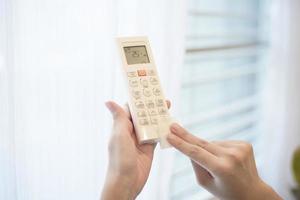 la donna sta pulendo il telecomando in casa foto