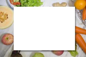 vari tipi di frutta e verdura con carta di carta bianca. disteso. concetto di alimentazione sana. foto