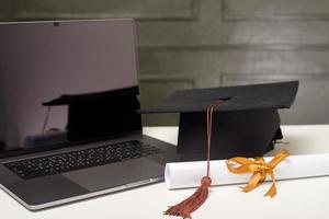 berretto di laurea con computer portatile, concetto di formazione online foto