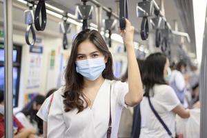 una giovane donna indossa una maschera protettiva in metropolitana, protezione covid-19, viaggi di sicurezza, nuova normalità, distanziamento sociale, trasporti di sicurezza, viaggi sotto il concetto di pandemia