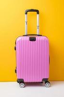 bagaglio rosa su sfondo giallo, concetto di viaggio