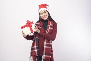 Ritratto di giovane donna sorridente che indossa il cappello rosso di Babbo Natale isolato sfondo bianco studio. foto