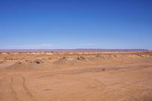 vista panoramica delle dune di sabbia nel deserto con le montagne sullo sfondo foto