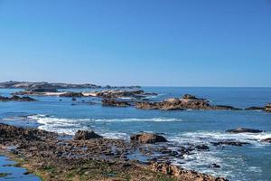 formazioni rocciose al litorale in mare contro il cielo blu chiaro foto