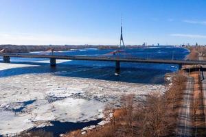 veduta aerea del ponte sud sul fiume daugava in lettonia con motivi a forma di ghiaccio che galleggiano nel fiume. foto