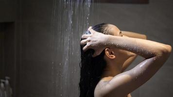 giovane bella donna che si lava i capelli in un bagno a casa foto