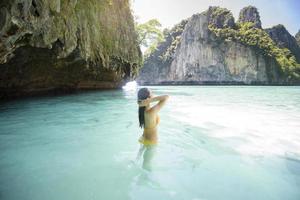 felice bella donna in costume da bagno giallo godendo e rilassarsi nel mare limpido, estate e concetto di vacanze foto