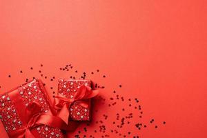 scatole regalo rosse con nastro per San Valentino che celebra su sfondo rosso solido con spazio per la copia foto