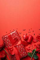 regali di san valentino, rose e candele su sfondo rosso, copia spazio foto