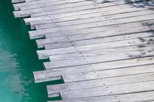 primo piano di un ponte di legno sul mare foto