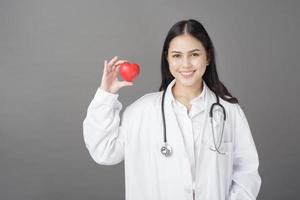 donna medico sta tenendo il cuore rosso foto