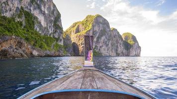 vista della tradizionale barca a coda lunga tailandese sul mare limpido e sul cielo nella giornata di sole, isole phi phi, tailandia foto