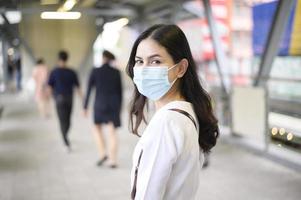 una giovane donna indossa una maschera per il viso nella città di strada.