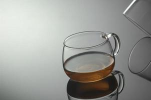 tazza da tè in vetro trasparente con riflesso foto