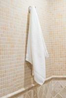 asciugamano di spugna bianco appeso nel bagno dell'hotel foto