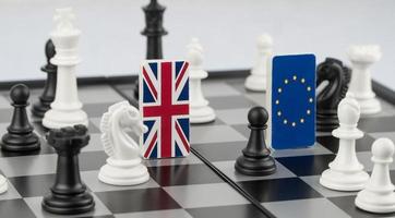 pezzi degli scacchi e bandiere dell'Unione europea e del Regno Unito su una scacchiera. il concetto di gioco politico e strategia scacchistica brexit foto