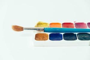 set di colori ad acquerello e pennelli per dipingere su sfondo bianco foto