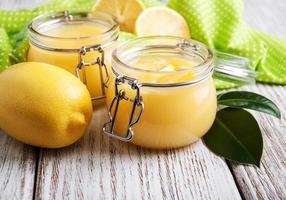 lemon curd in vasetto di vetro con limoni freschi foto