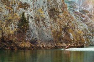 i turisti fanno rafting lungo il fiume di montagna in kayak foto