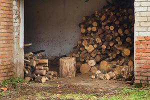 hangar con tronchi e ponti di legno. raccogliere legna da ardere per l'inverno. foto