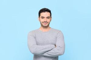 ritratto di un bell'uomo sorridente e amichevole in t-shirt grigia con le braccia incrociate isolato in studio azzurro bakground foto