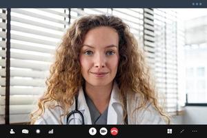 dottoressa guardando la telecamera mentre effettua una videochiamata con il paziente online, concetti di servizio di consulenza medica domiciliare foto