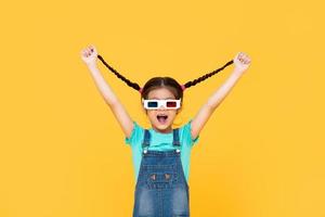 divertente ritratto di giovane ragazza eccitata che indossa occhiali da cinema 3d con entrambe le braccia sollevate tirandosi i capelli in uno sfondo giallo studio isolato foto