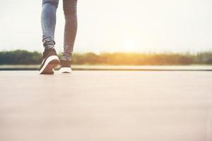 piedi di donna che camminano sul ponte di legno, da soli. foto