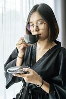 donne che indossano abiti neri, che porgono il caffè in camera da letto. foto