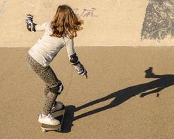 bambina che guida lo skateboard foto